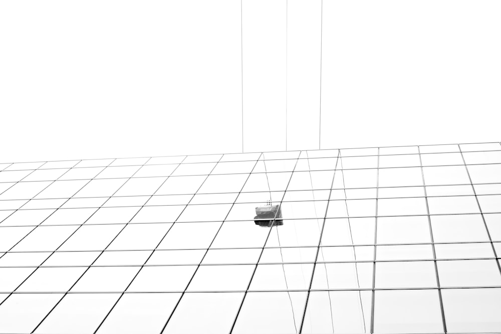 a black and white photo of a cell phone hanging from a wire