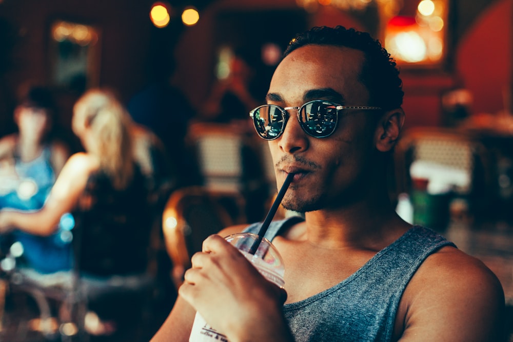 man sipping cooler while sitting on chair