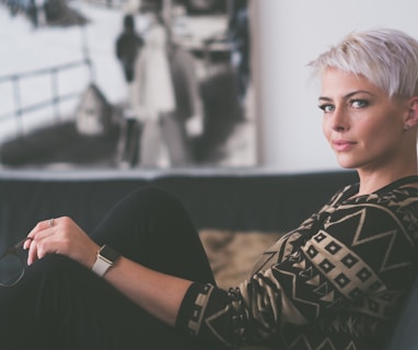 woman sitting on sofa holding eyeglasses