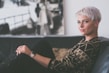 woman sitting on sofa holding eyeglasses