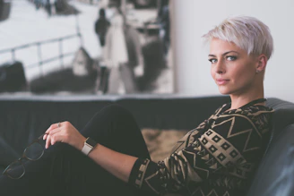woman sitting on sofa holding eyeglasses at vancouver facelift clinic