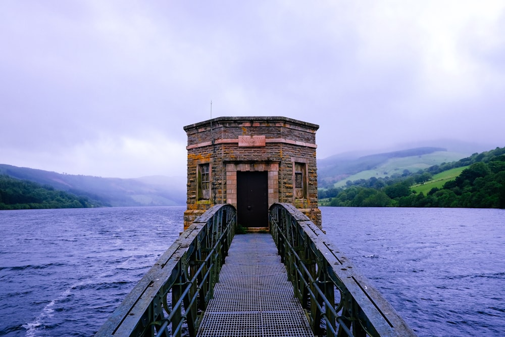 black metal bridge leading to building surrounded by water