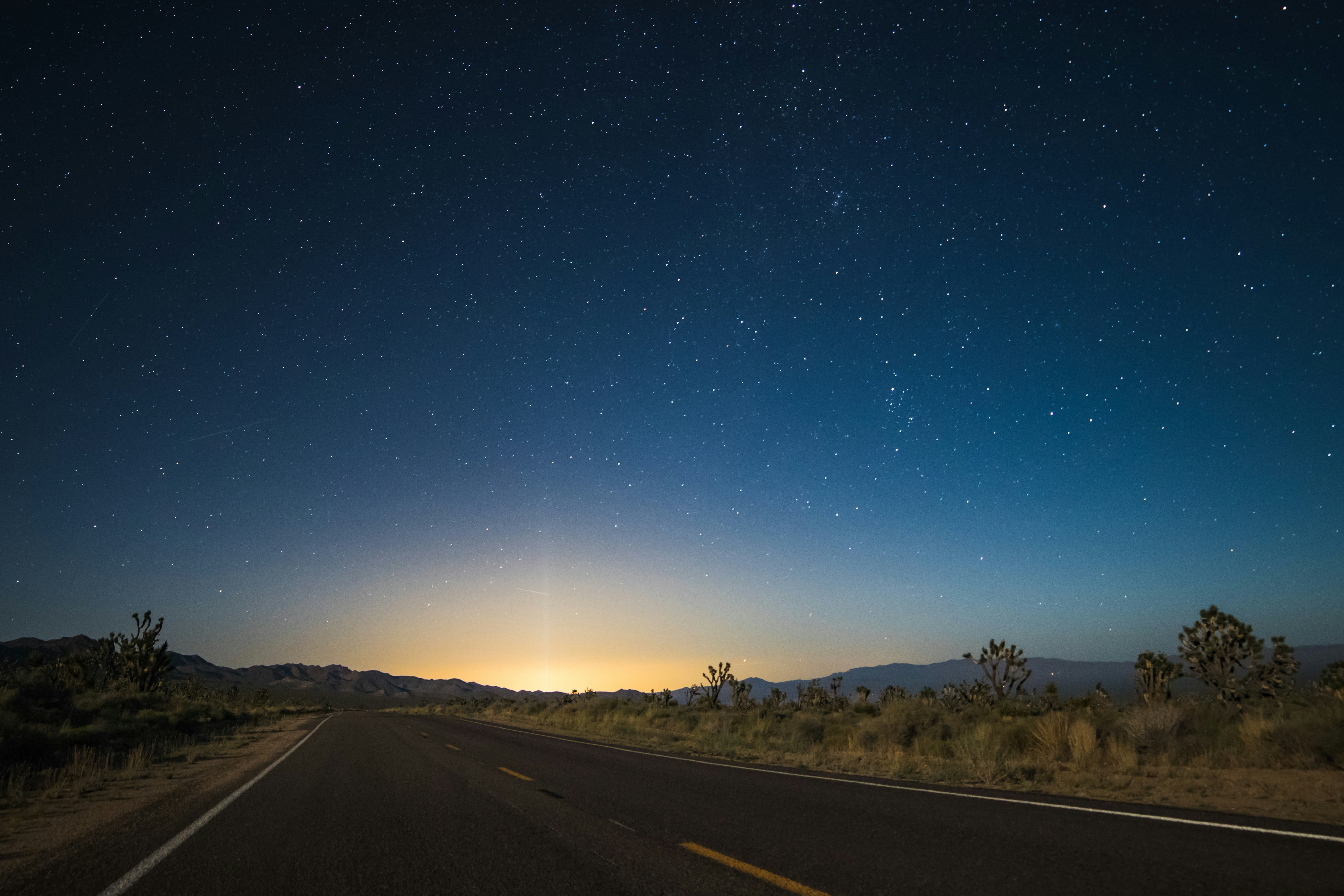 asphalt road in the middle of brown field, Starry sky transition at Nipton