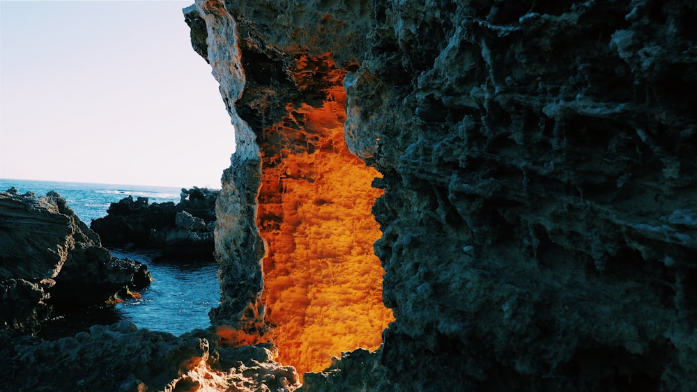 lighted cave entrance near body of water