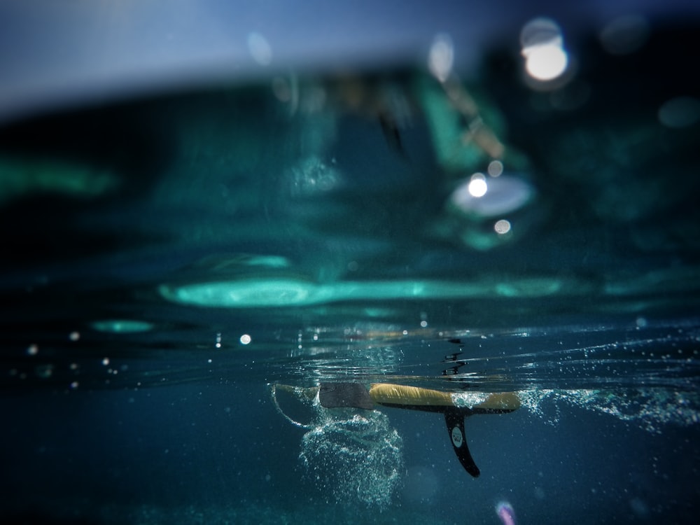 close up photo of black surfboard fin underwater