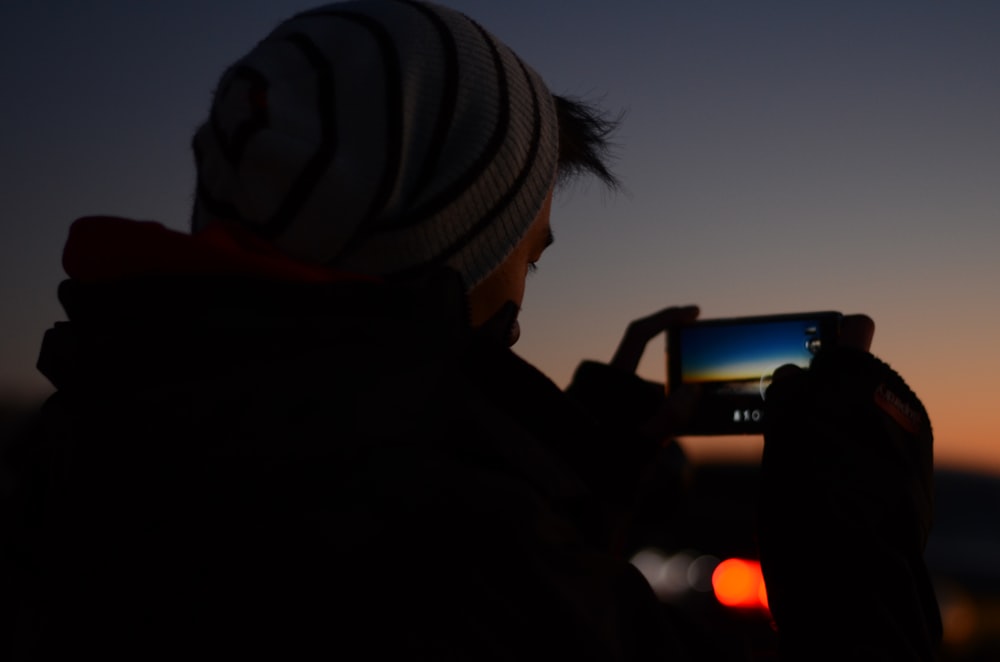 hombre sosteniendo el teléfono para tomar una foto