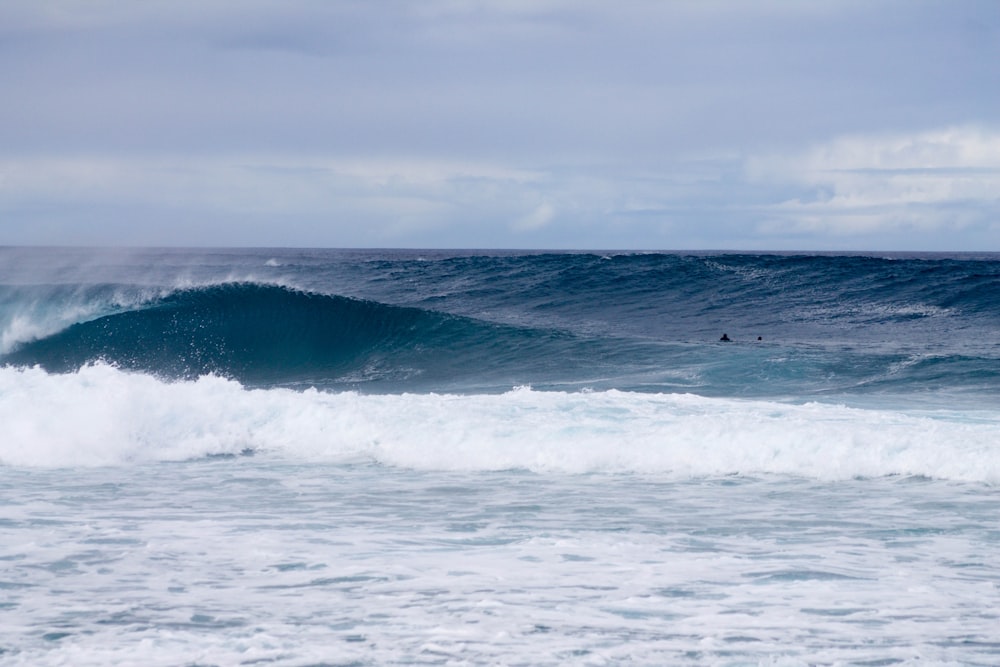 A large wave makes its way to the beach's shore.