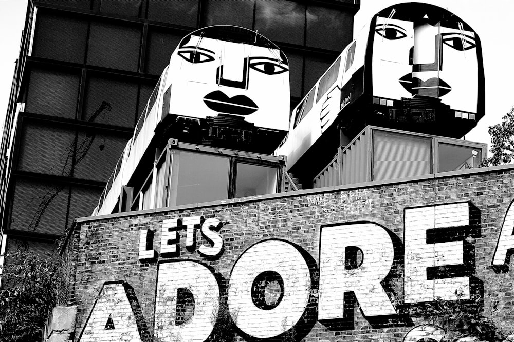 une photo en noir et blanc d’un panneau qui dit Adorons