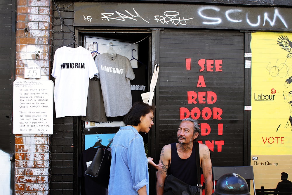 a man talking to a woman in front of a store