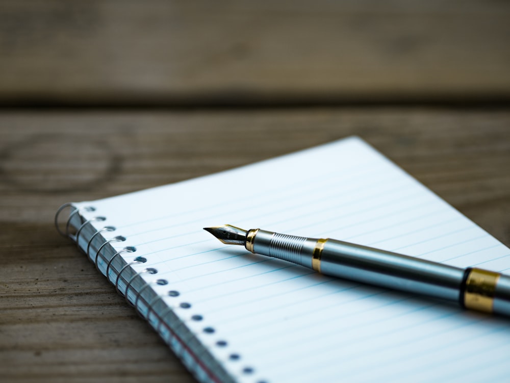 A fountain pen on a spiral notebook