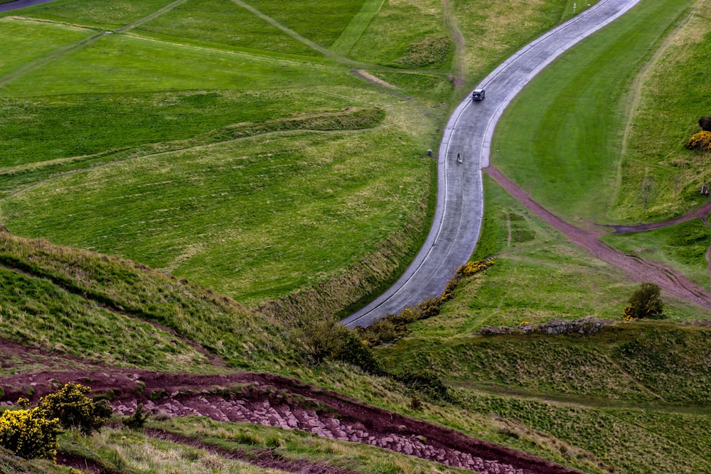 Carretera sinuosa cerca de un campo de hierba verde