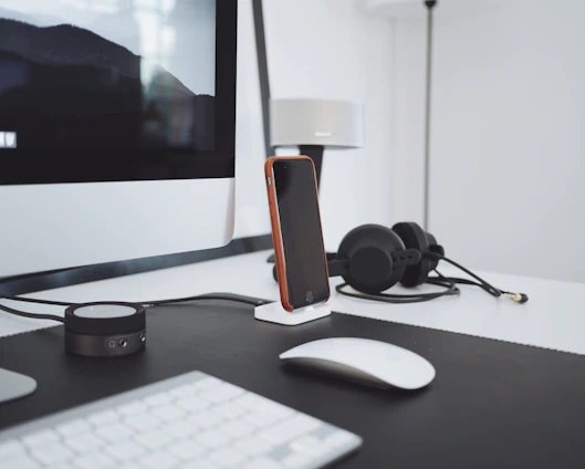 A cozy workspace with a laptop, smartphone, and headphones, reflecting a modern tech review setup.