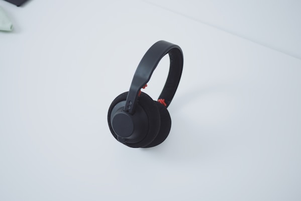 A pair of stylish wireless headphones resting on a minimalist white table.