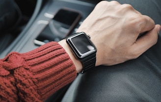 person wearing black case Apple Watch with white Sport Band