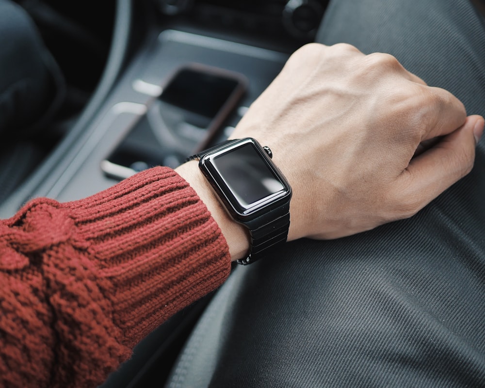 person wearing black case Apple Watch with white Sport Band