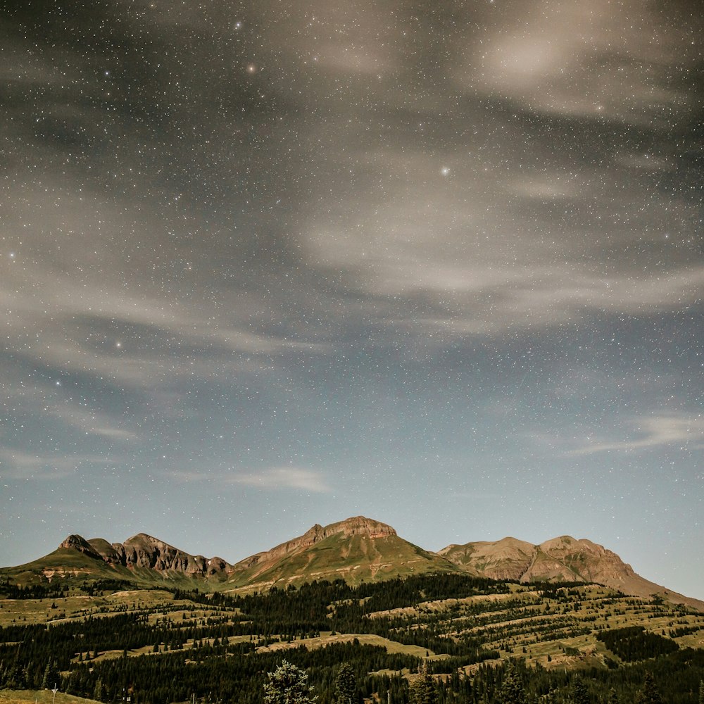 mountains under cloudy blue sky