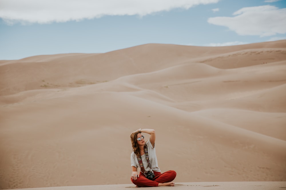 fotografia minimalista di donna seduta su terreno desertico