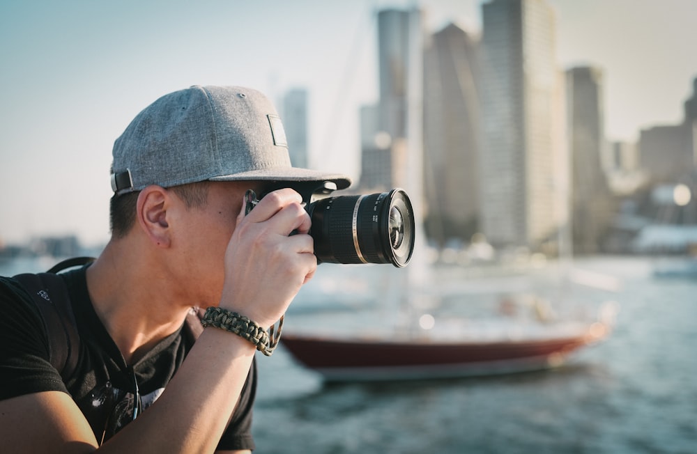 man holding black DSLR camera