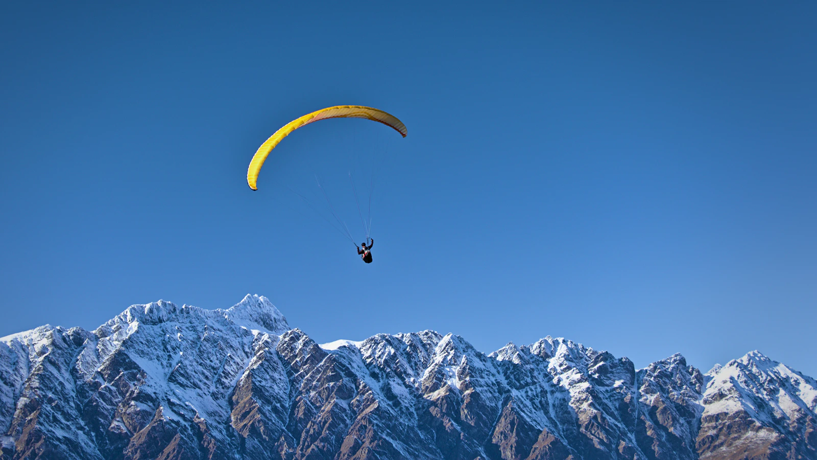 Man on parachute near the mountain