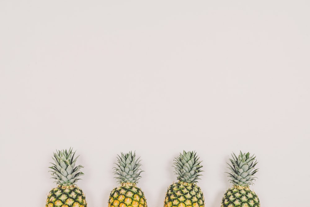 quatre ananas sur fond blanc