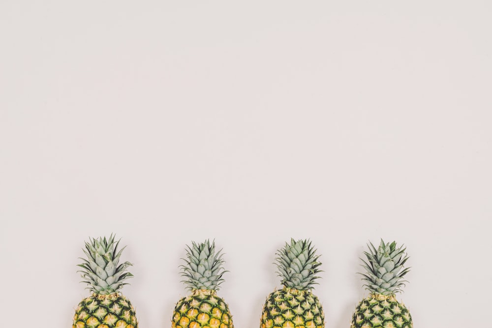 four pineapples on white background