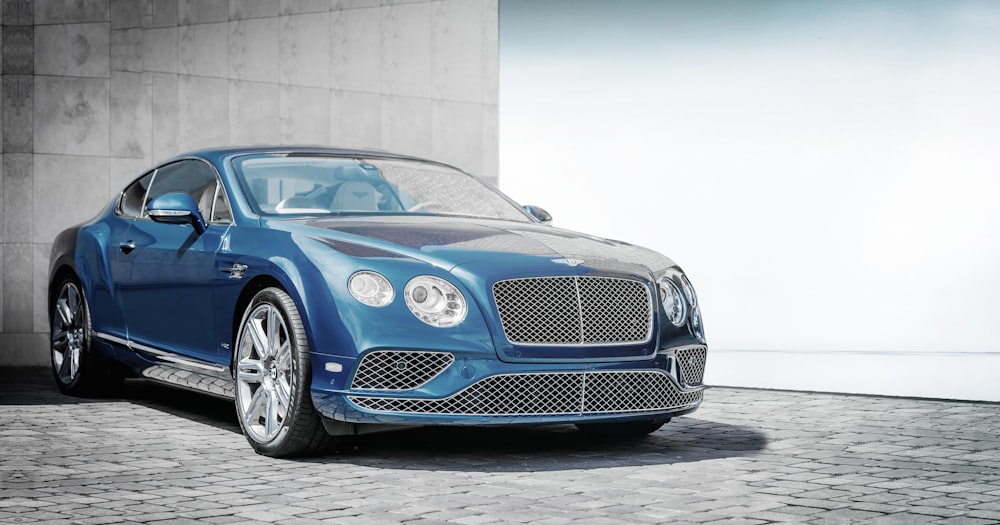 Luxury blue Bentley car parked on a gray street