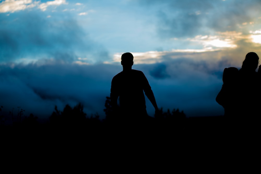 silhouette of person walking towers trees