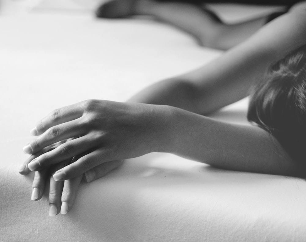 grayscale photo of person lying on bed