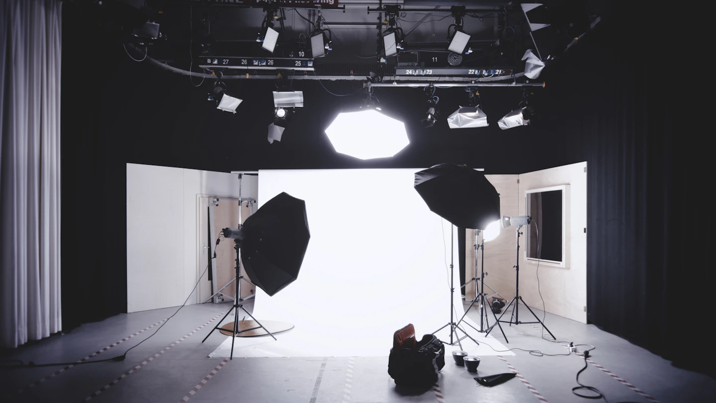 An empty photo studio with softboxes and a white backdrop