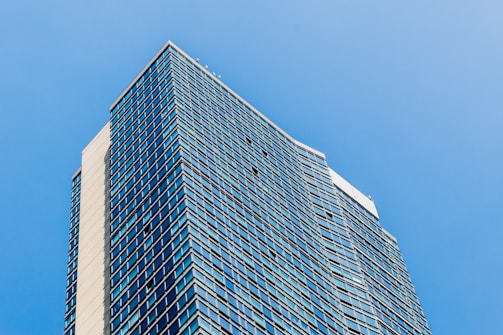 A panoramic shot of a completed commercial building with reflective glass windows against a clear sky.