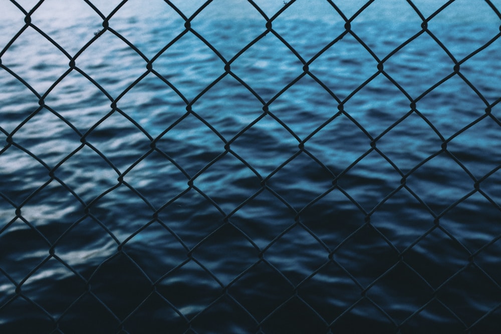 body of water in front of chain link fence