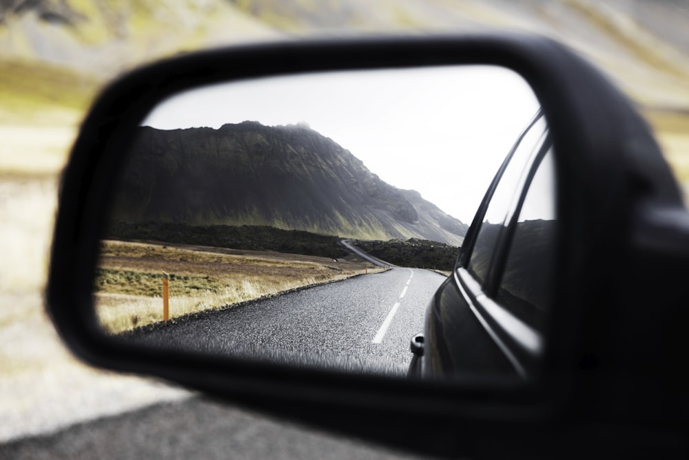 specchietto retrovisore esterno nero che mostra la strada