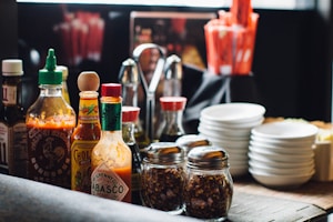 An assortment of colorful fermented sauces on a wooden table.
