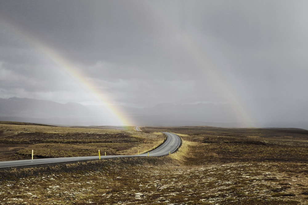 photo de paysage de route sous les arcs-en-ciel