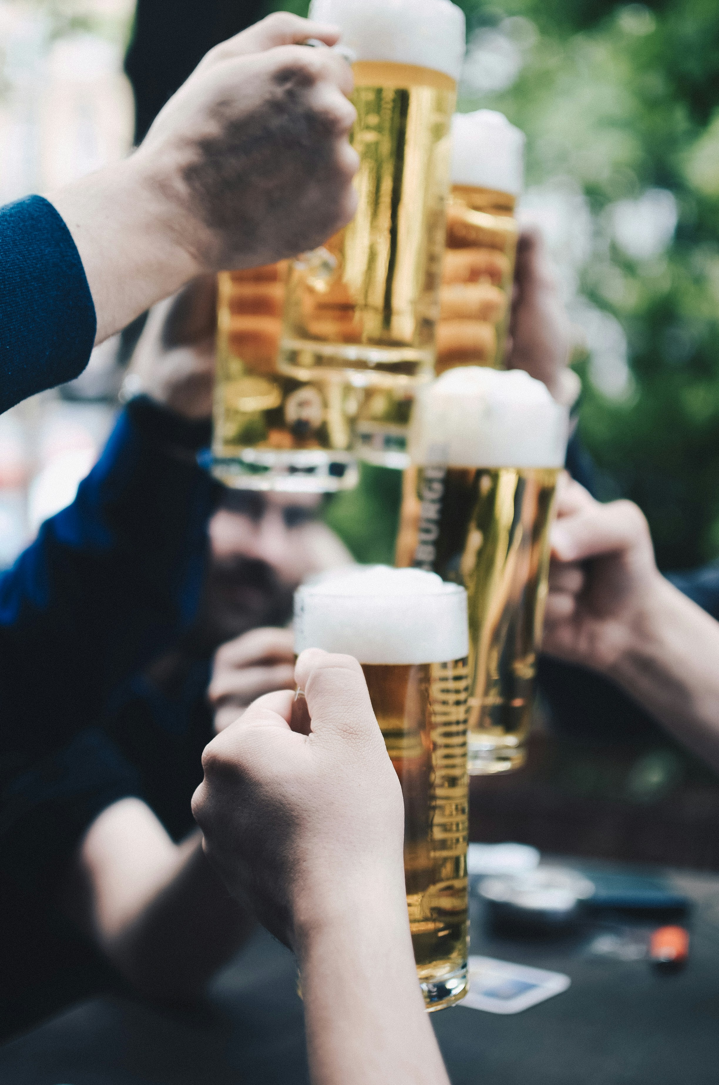 Several hands holding beer glasses