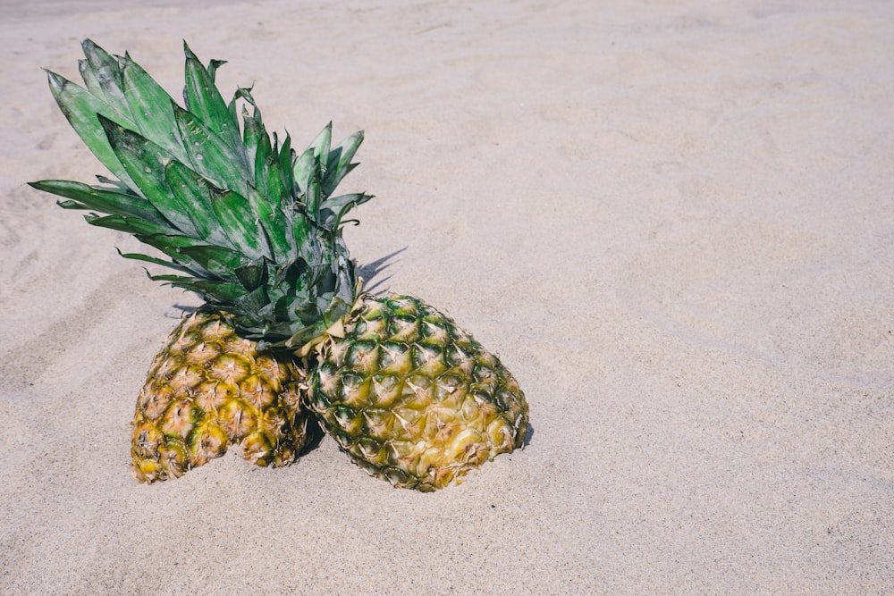 deux ananas sur sable gris