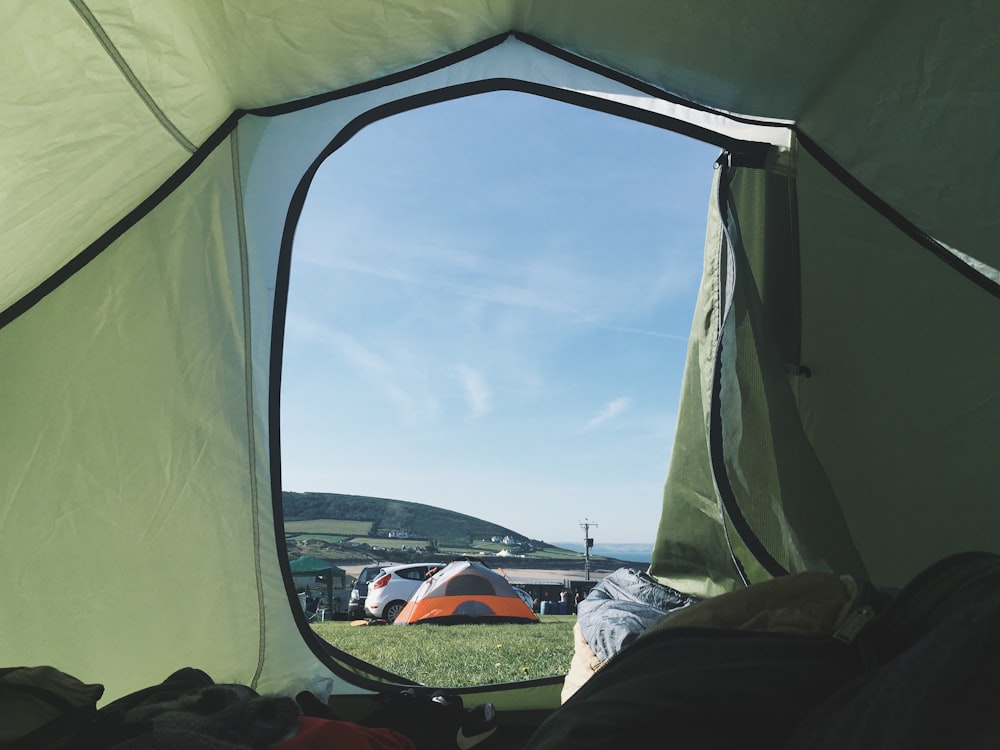 テントの中の人、灰色とオレンジ色のテントの背景