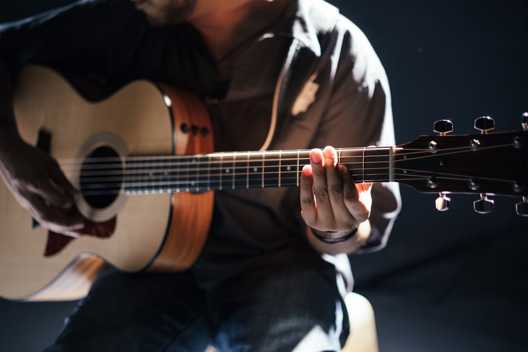 Acoustic guitar player in pale light