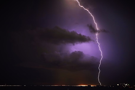 A dramatic lightning bolt striking against a dark stormy sky.