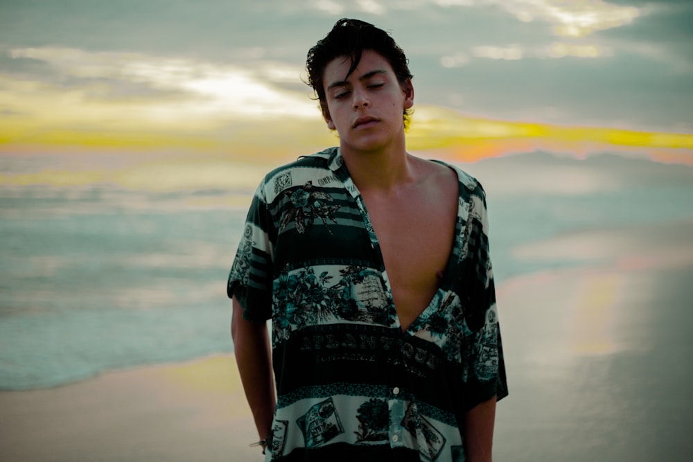 man wearing black and teal shirt on sea shore