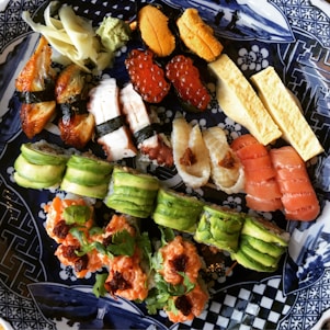 A beautifully arranged sushi platter with various types of sushi and garnishes.