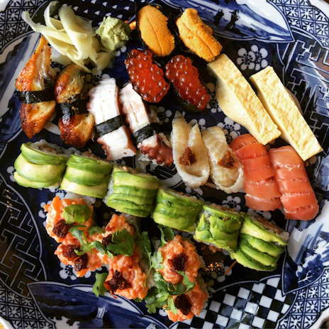 A beautifully arranged sushi platter showcasing fresh fish and delicate garnishes.