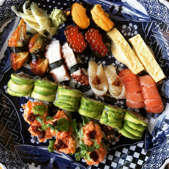 A beautifully arranged sushi platter with various types of sushi and garnishes.