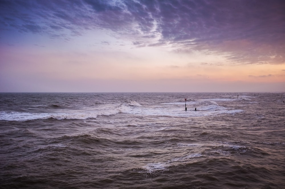 body of water under cloudy sky