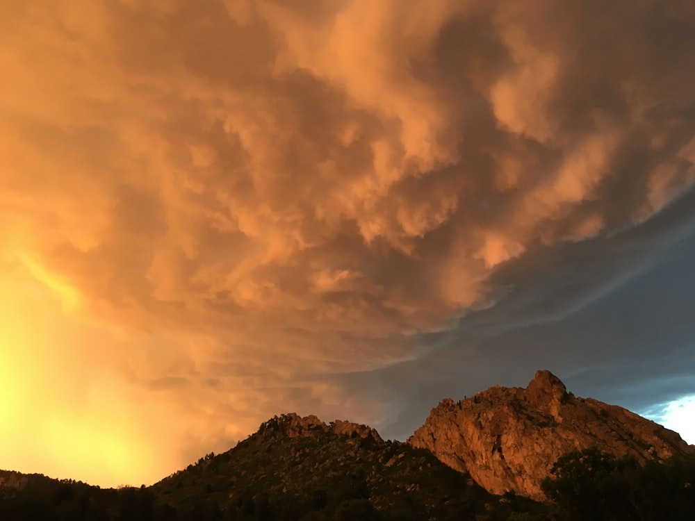 montagne brune sous des nuages blancs