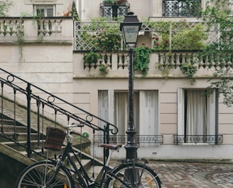 bike leaning against handrail in front of concrete building at daytime