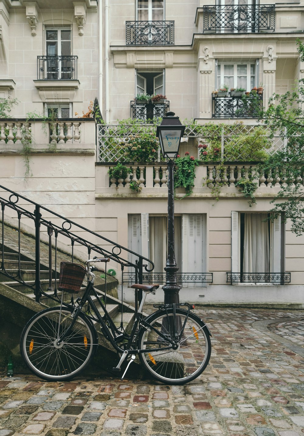 bike leaning against handrail in front of concrete building at daytime