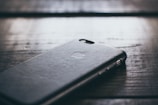 Close-up of a sleek matte black iPhone case on a wooden table.