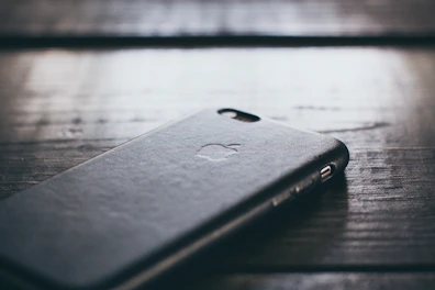 Close-up of a sleek mobile cover with a bold graphic design on a wooden table.