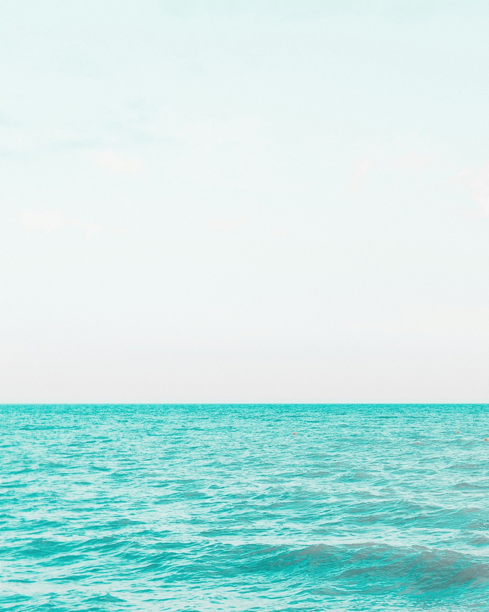 body of water under white sky during daytime